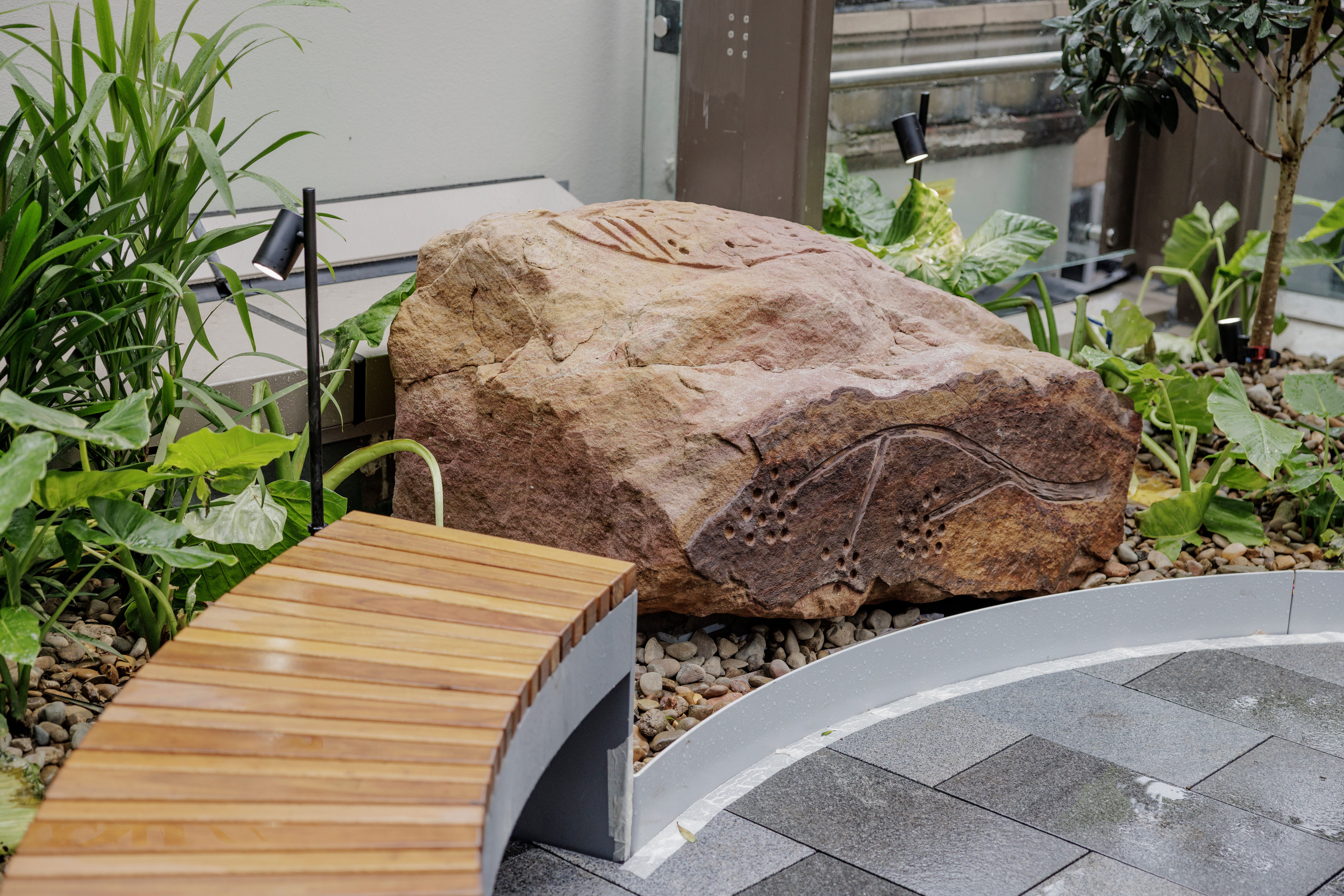Photo of a sandstone boulder featuring Jamie Eastwood's rock carvings