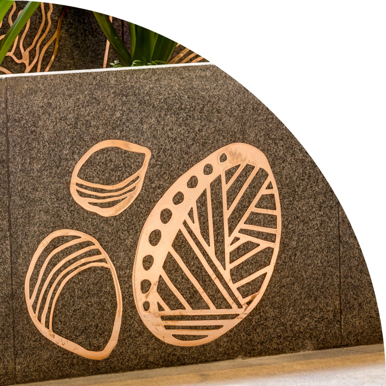 Close-up of copper inlay in stone, with native landscaping