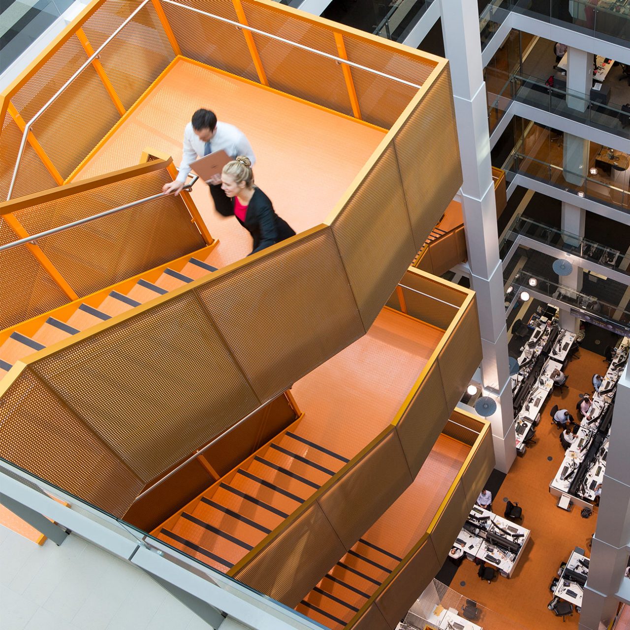 Top of the internal stairs inside 50 Martin Place, looking down to people walking on the stairs and desks below