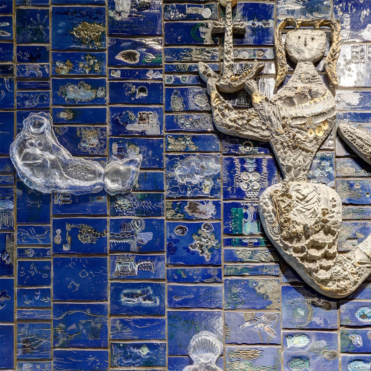 Close-up of Douglas Annand's Ceramic Wall Mural, featuring glass resin mermaids